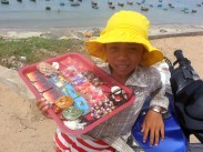 Young girl selling trinkets along the waterfront in Vietnam.